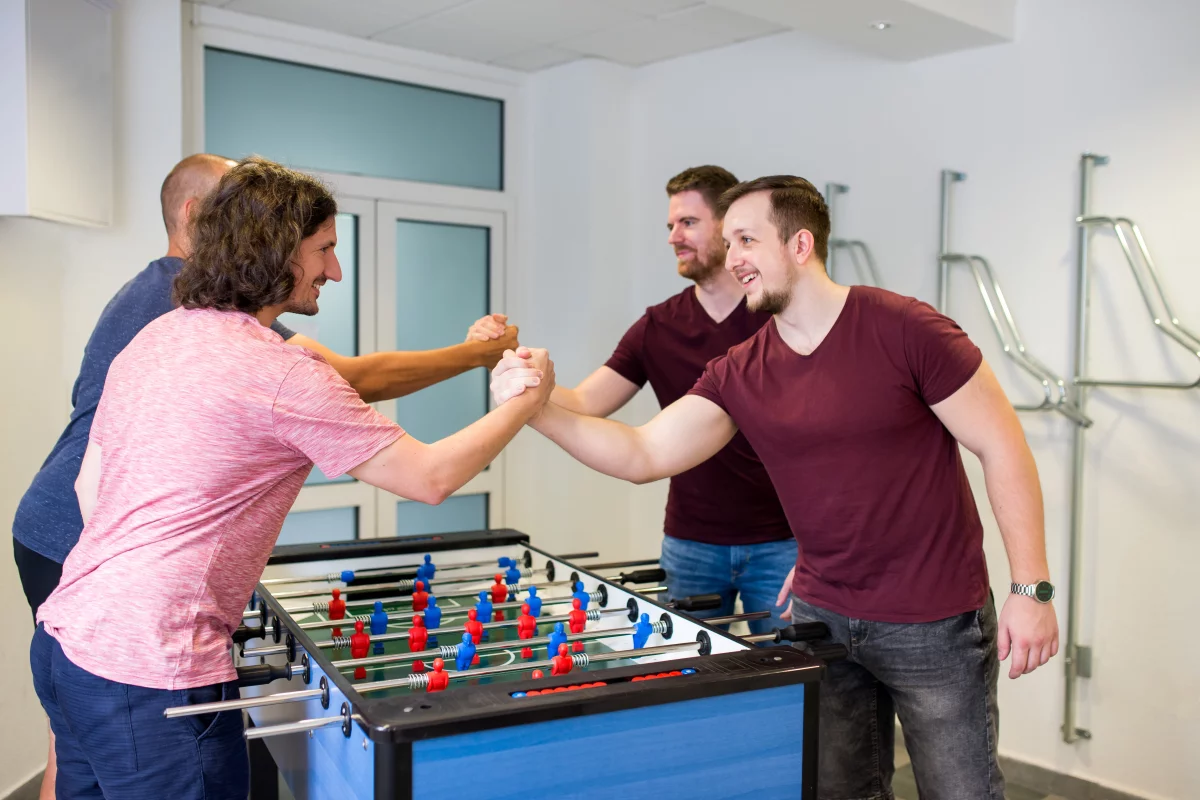 Lukáš hrá so svojimi kolegami stolný futbal 