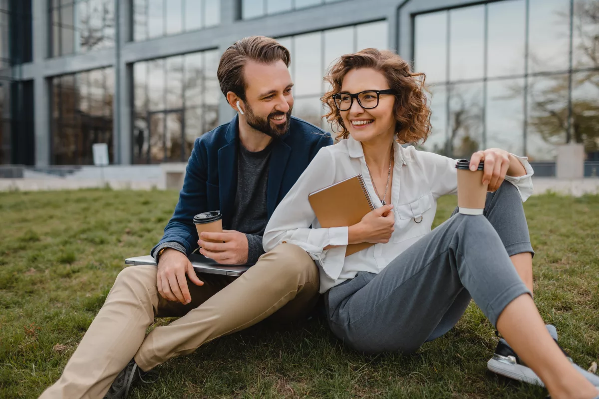 dvaja kolegovci sedia na tráve a bavia sa