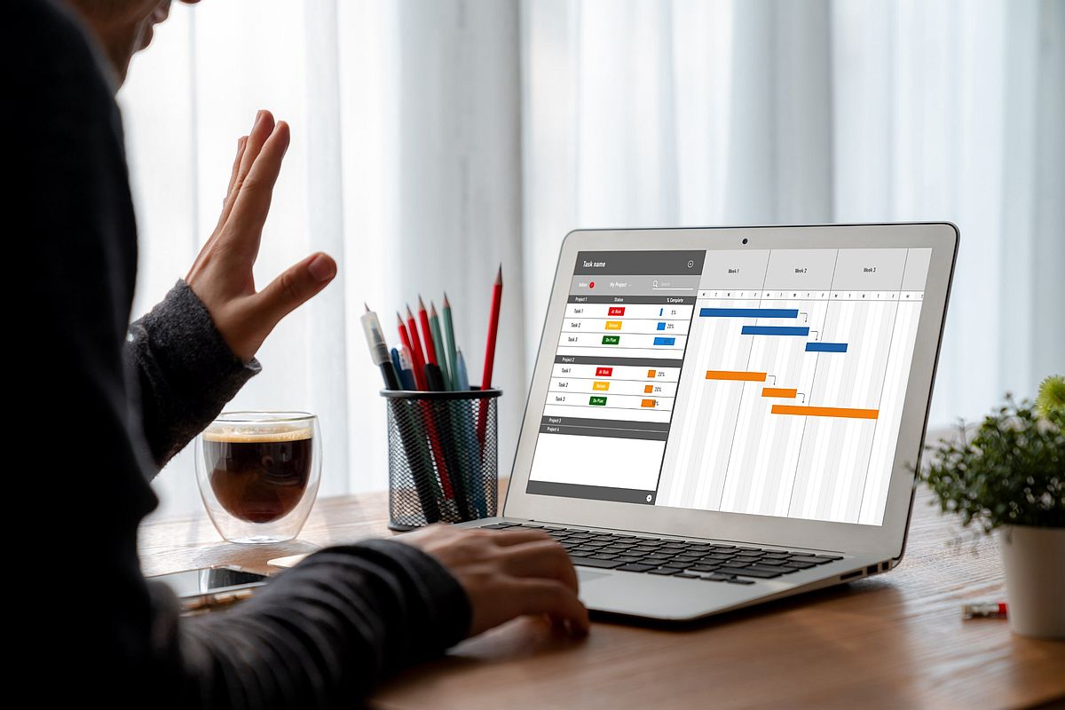 IT projektový manažér kontroluje časový graf projektu na laptope