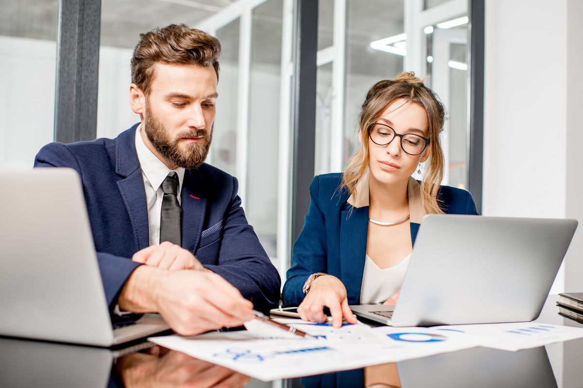 poistny-trh-digitalizacia-zaviedla-bezkontaktne-sluzby-1200-800 – msg life Slovakia muž a žena vo formálnom oblečení, zamestnanci poisťovne, si prezerajú grafy na papiery