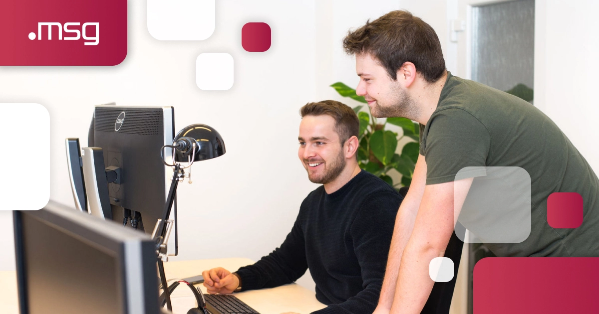 IT špecialisti z msg life Slovakia konzultujú pri počítači